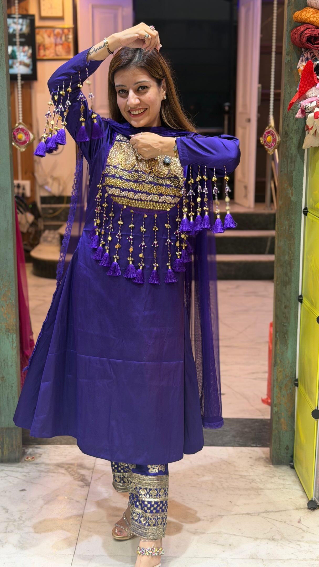 Ruhi showing the golden tassel details of Qayanat’s royal-purple suit